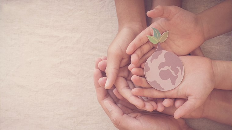 Dłonie dorosłej osoby i dzieci trzymające kartonikową planetę - Dbanie o środowisko – jak możesz pomóc?