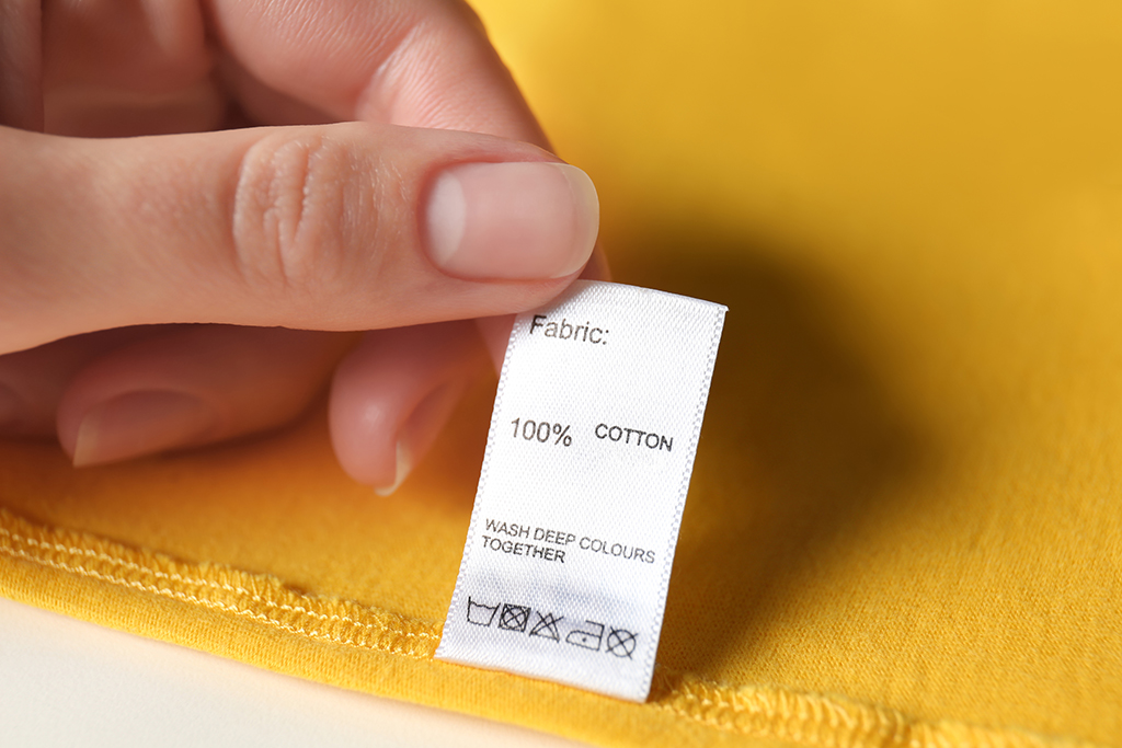 Kobieta czytająca etykietę odzieży - Jak kupować bardziej eko