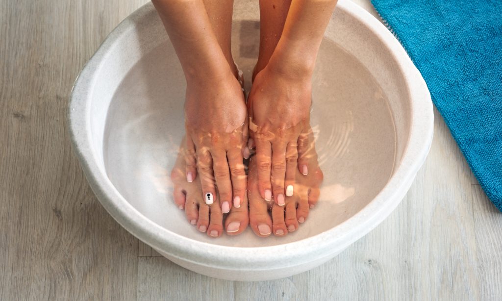 Zbliżenie na stopy i ręce kobiety w misce z wodą – Domowe SPA
