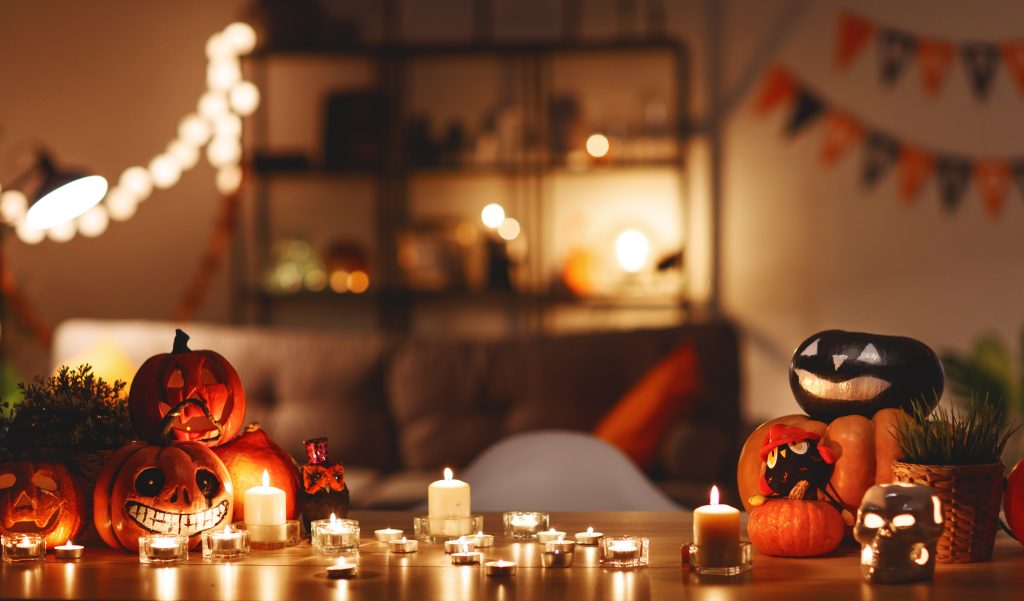 Stół zastawiony na Halloween z dyniami o świeczkami